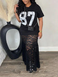 Woman wearing a black t-shirt with white numbers and a black lace skirt, standing next to a black vase.